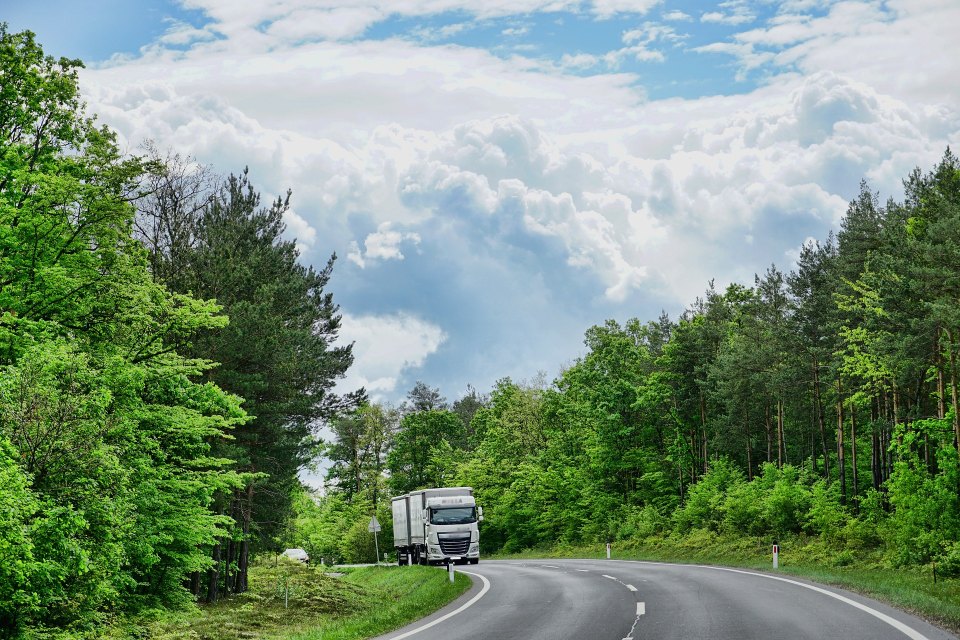 Truck driving on a curved forest road