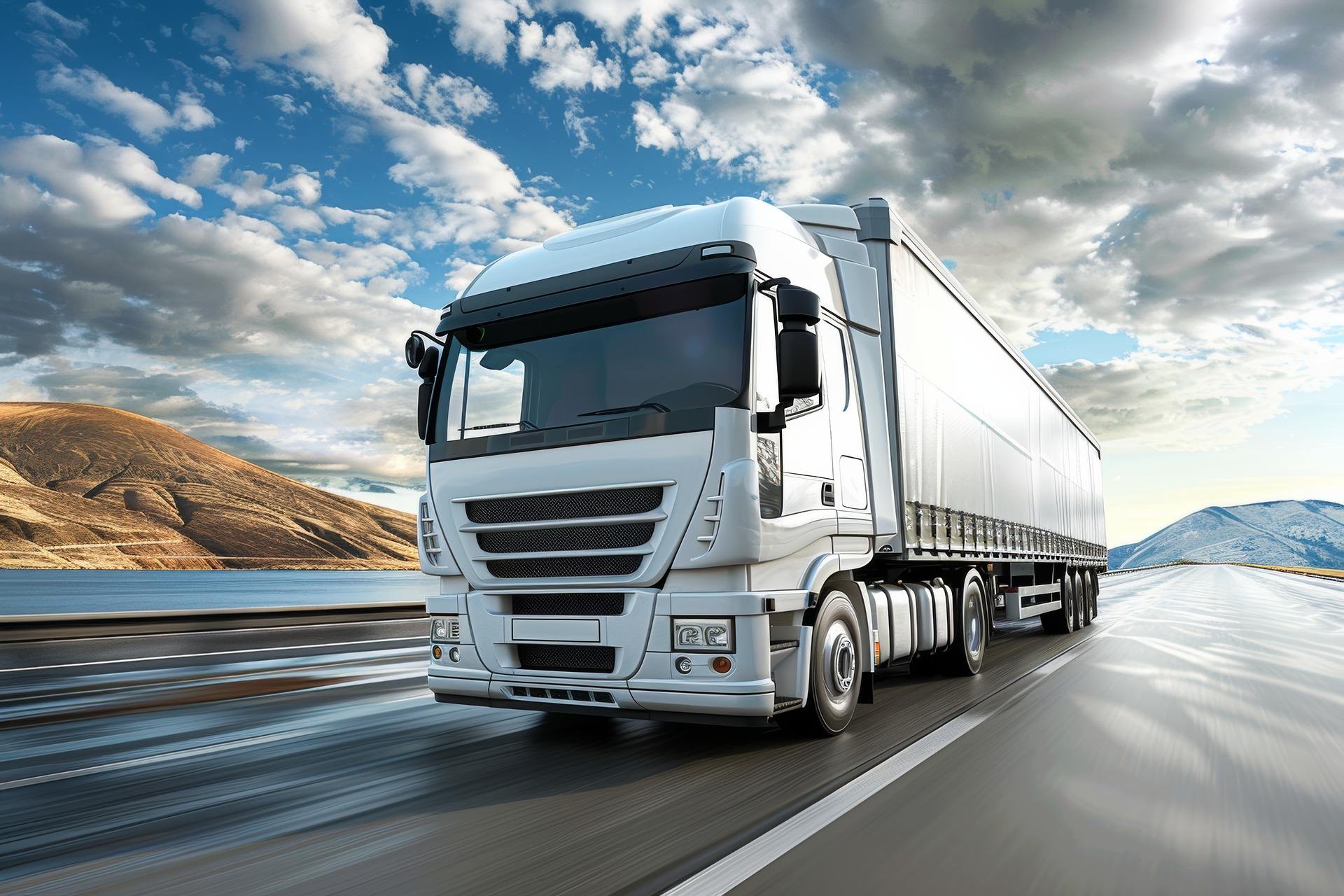 Large white truck on highway with mountains